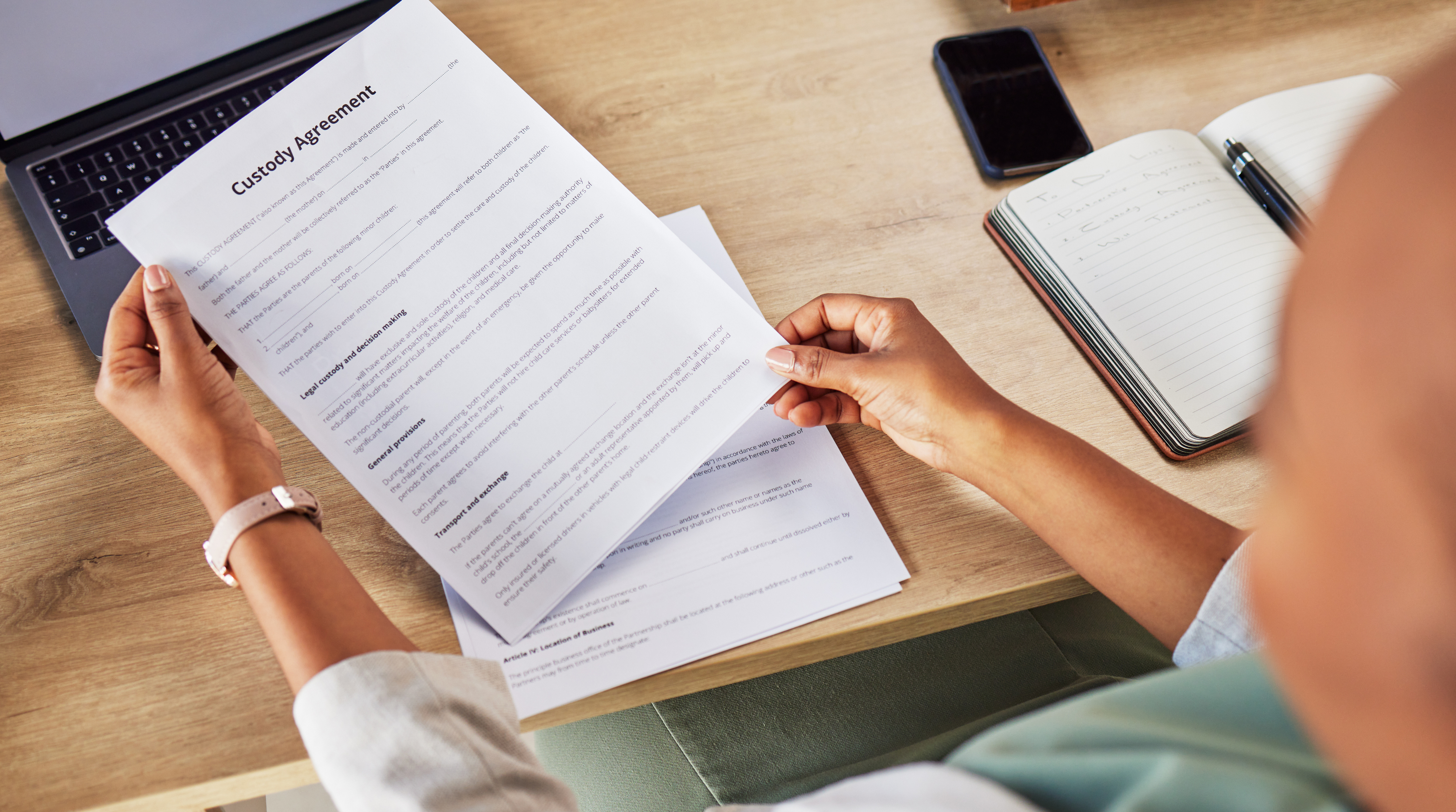 Man sitting at desk in Huntersville North Carolina reviewing a child custody contract and legal paperwork with focus and concern