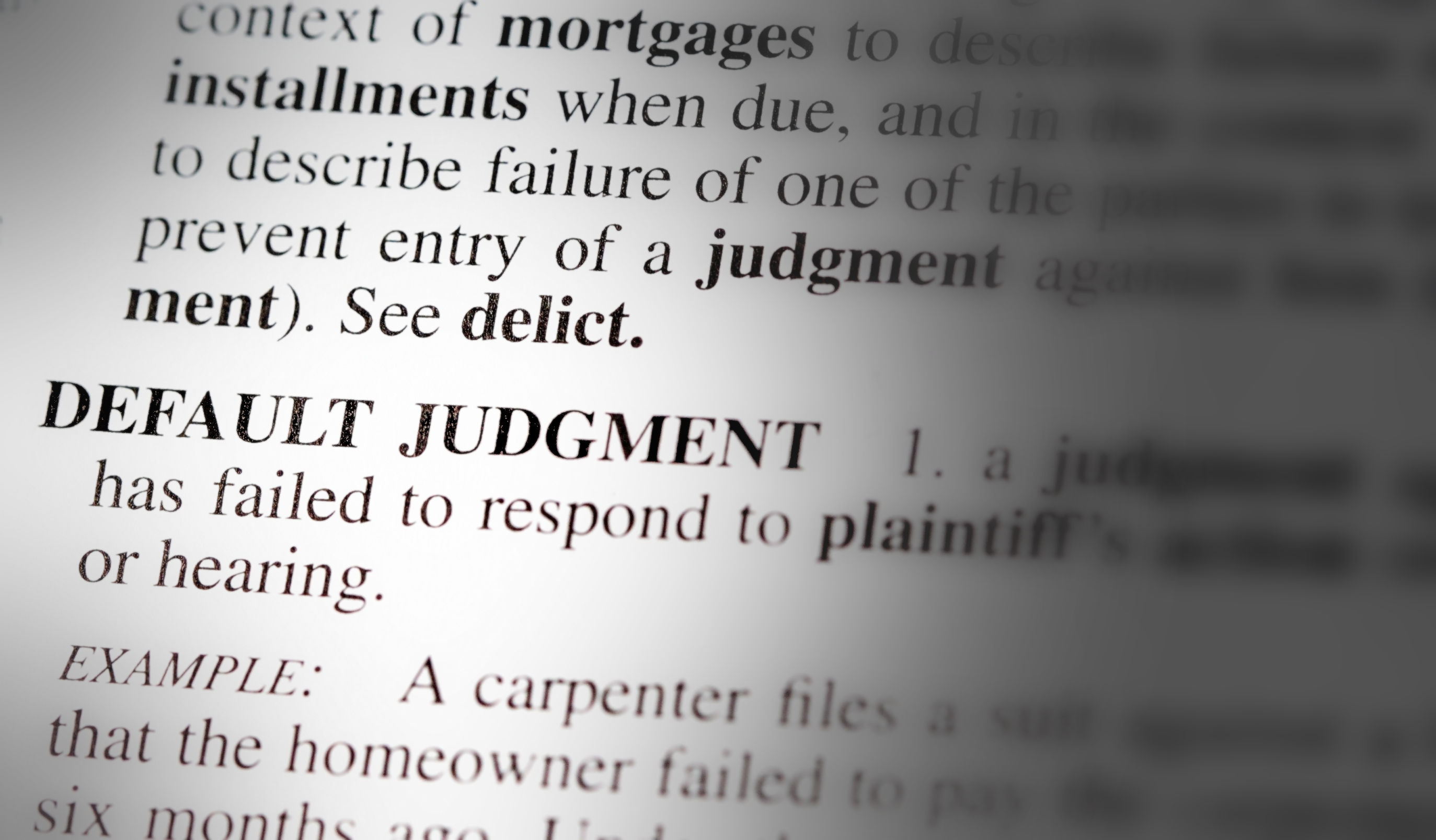 Close up of the words default judgment and its definition printed in a legal dictionary or reference book in Huntersville NC