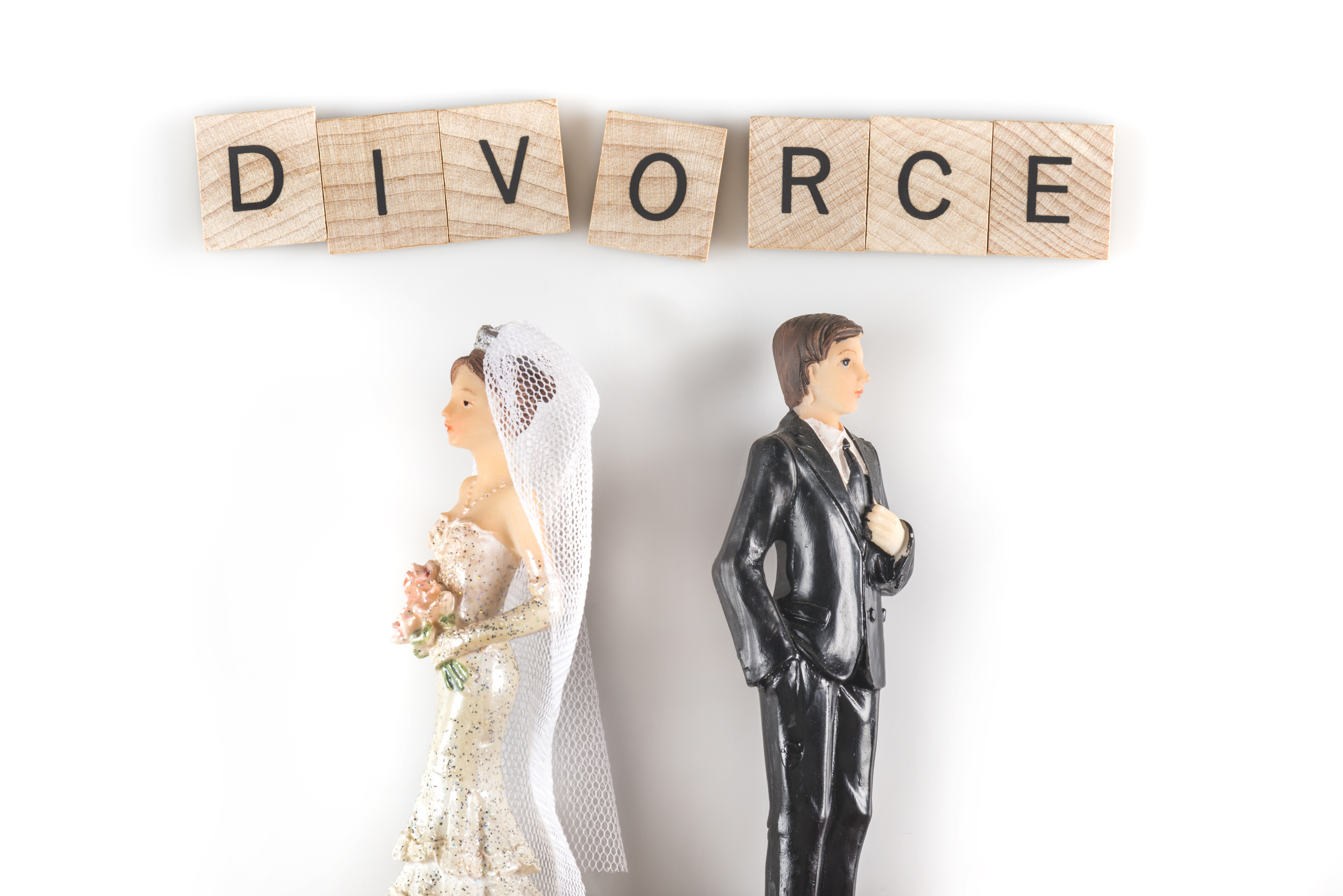 Bride and groom standing apart, removing wedding rings, symbolizing divorce and the end of a marriage in Huntersville, NC.