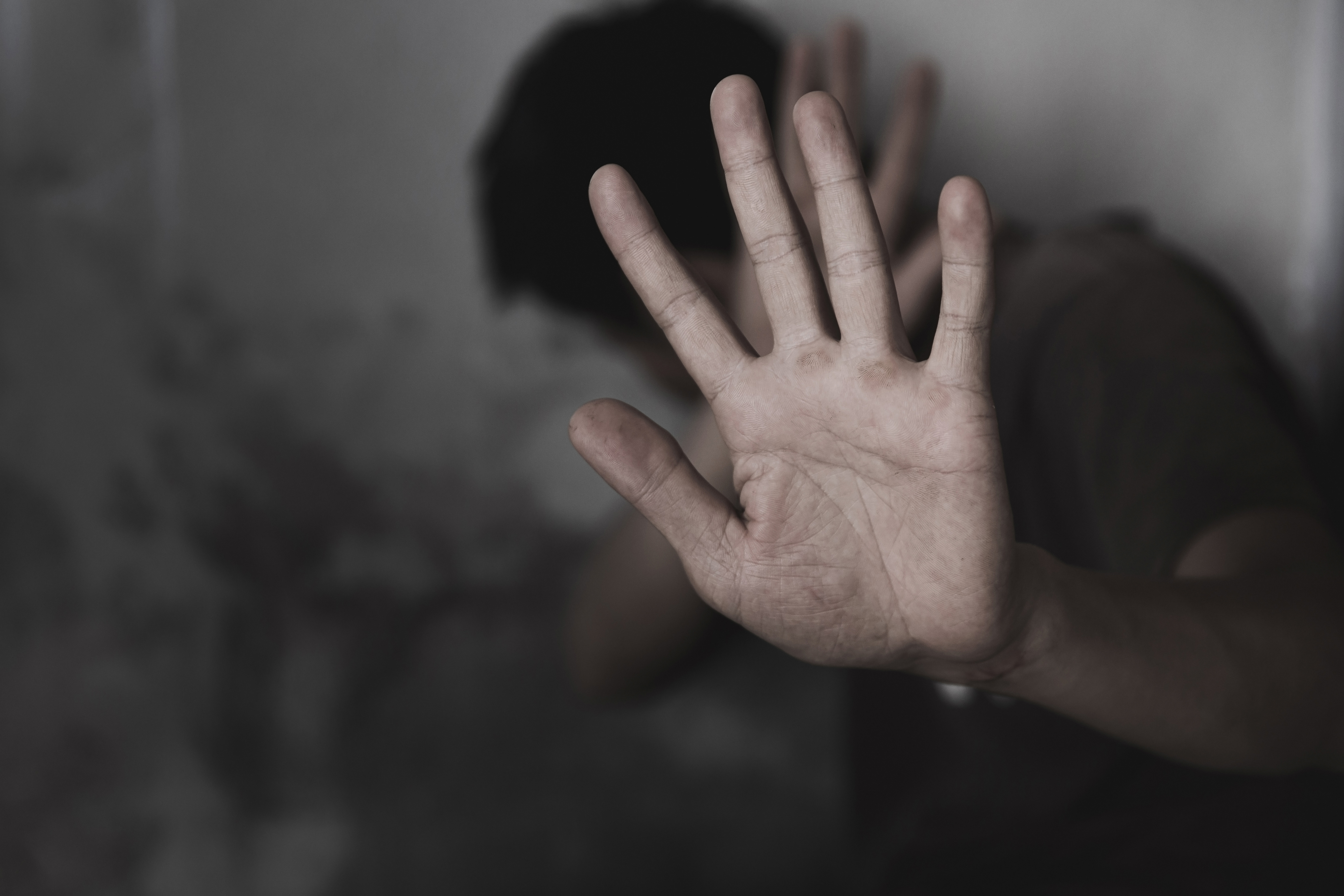 Distressed man in Huntersville NC holding up his hand defensively symbolizing fear protection and the need for safety in a domestic violence situation