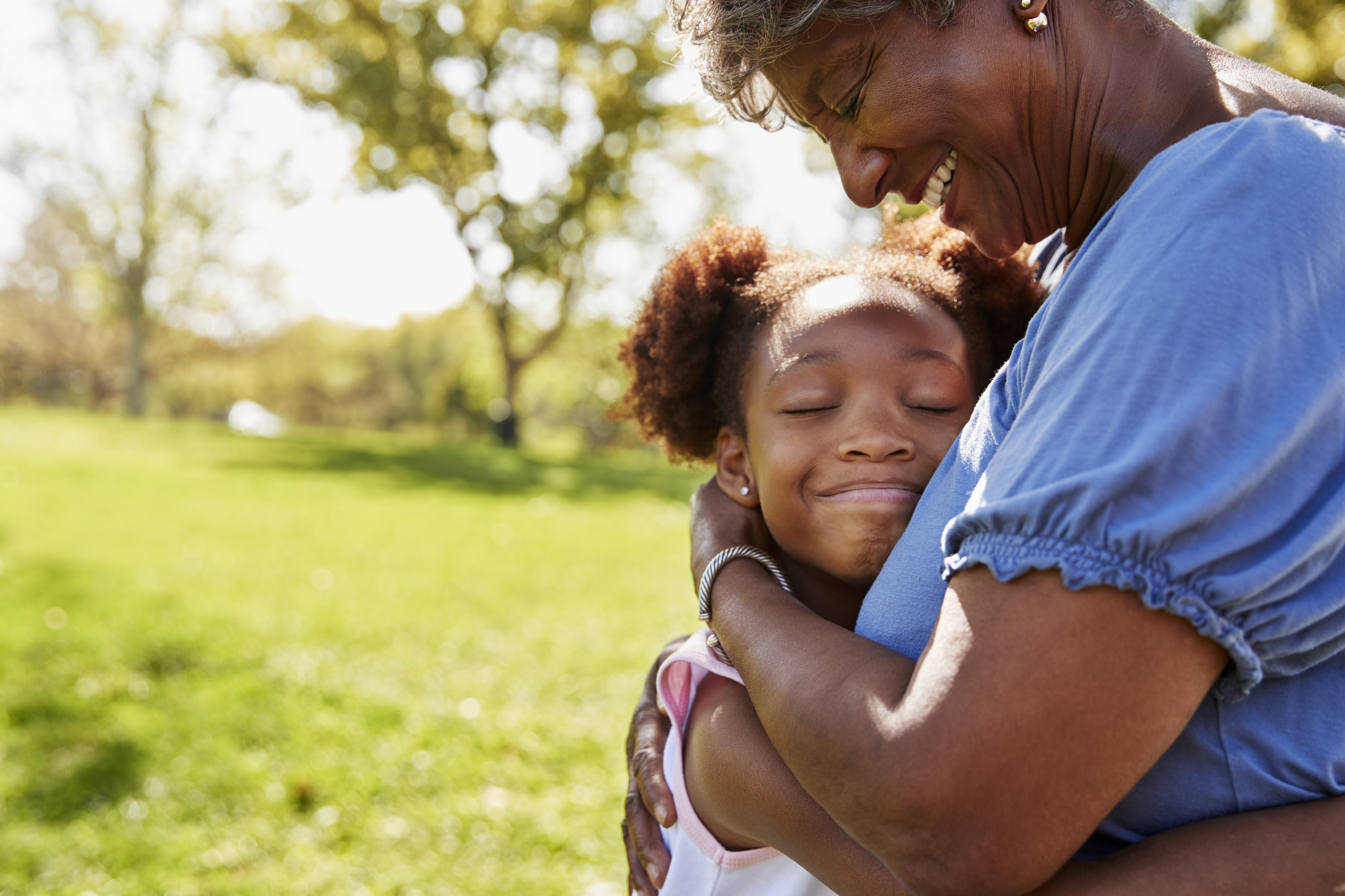 Grandmother hugging her grandchild outdoors celebrating a custody victory and expressing love protection and family bond